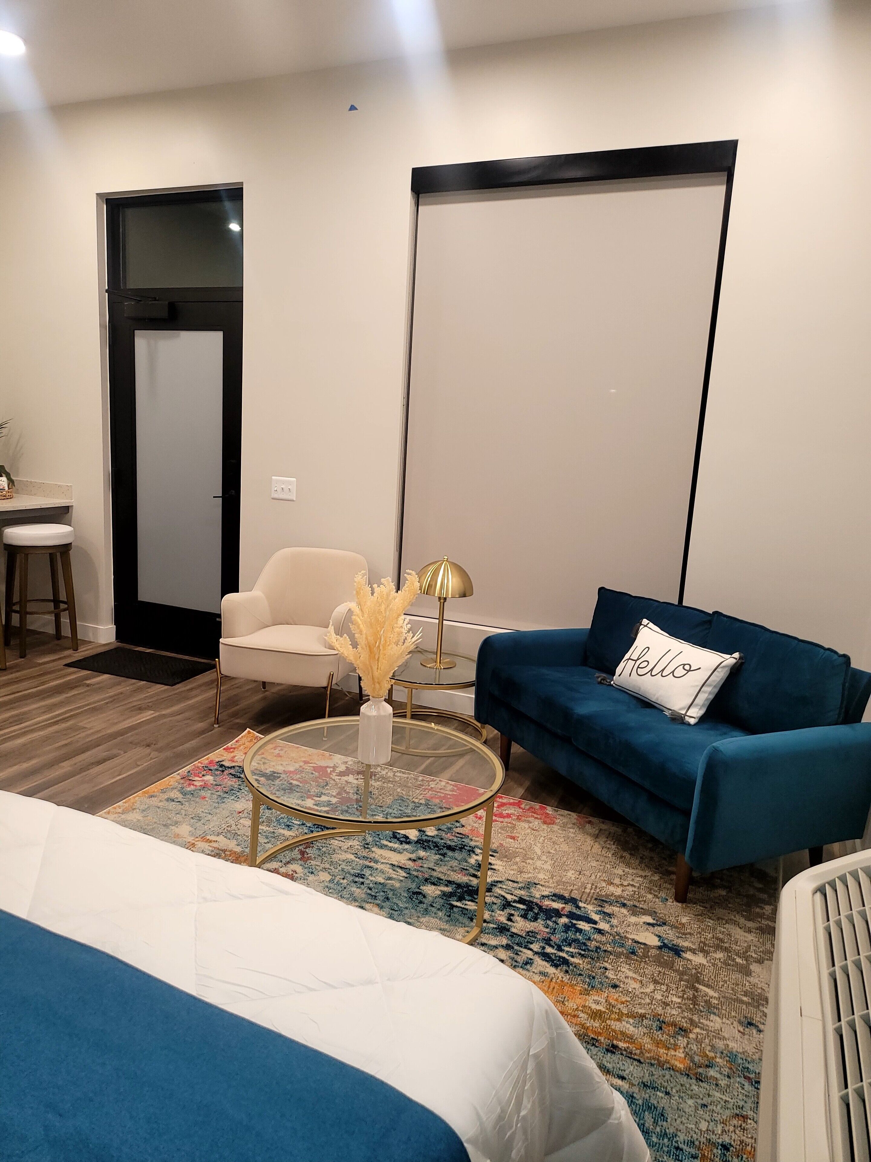 A modern living room with a sofa, a coffee table, a chair, and a bed.