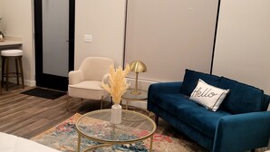 Ein modernes Wohnzimmer mit einer Couch, einem Couchtisch, einem Sessel und einem Bett.