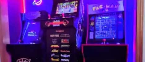 Arkademaskiner med neonskilte, blandt andet Pac-Man og Space Invaders.