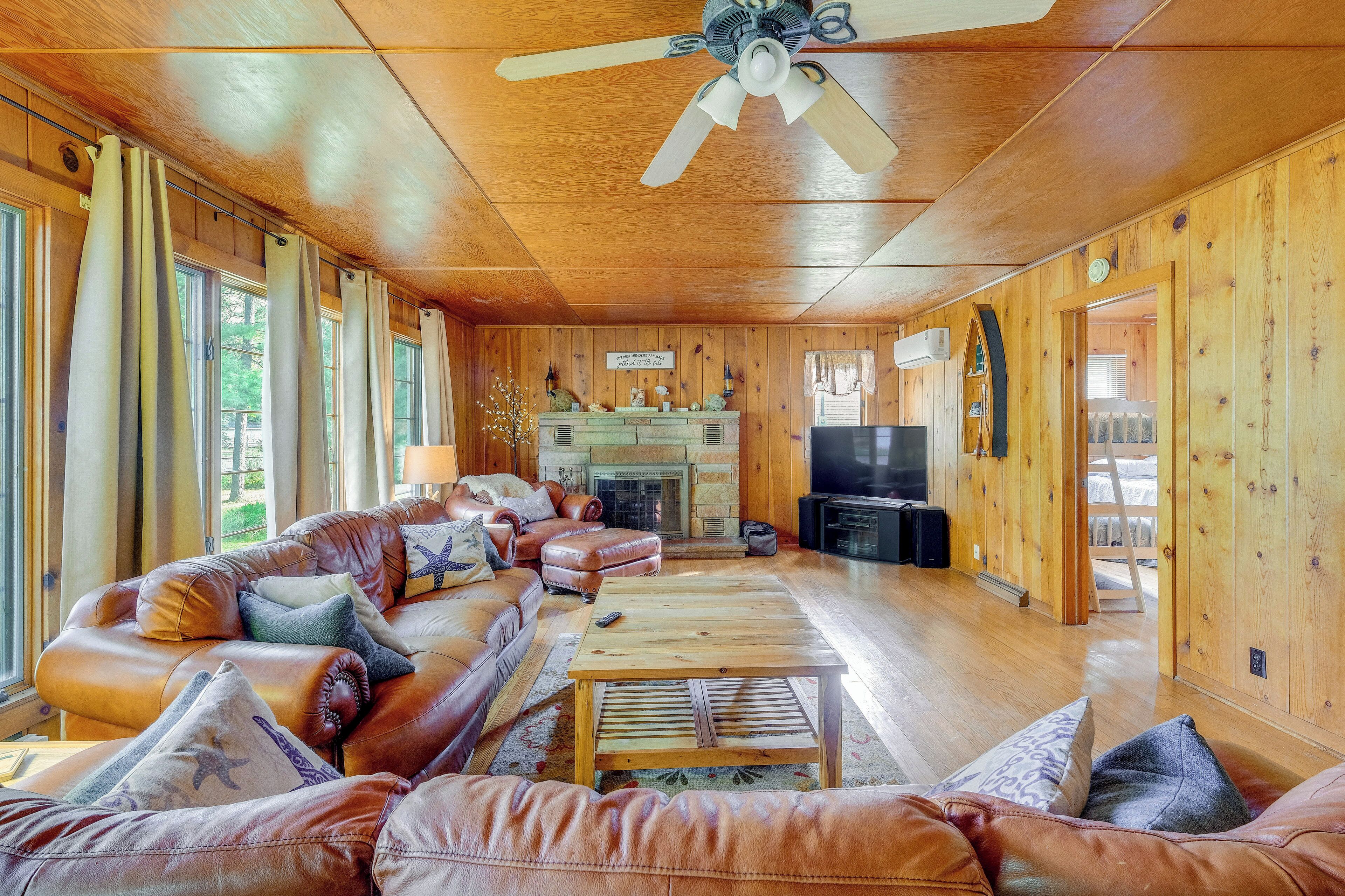 A cozy living room with leather sofas, a wooden coffee table, and a fireplace.