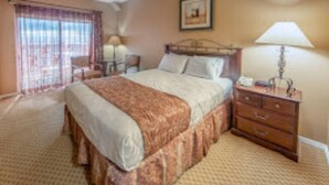 A hotel room with a bed, a nightstand, a lamp, a chair, and a window with curtains. - Stunning, sought after David Walley's Amazing Resort in the beautiful mountains! (Genoa)