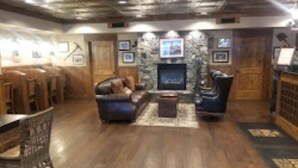 A cozy living room with a stone fireplace, comfortable seating, and wooden flooring. - Stunning, sought after David Walley's Amazing Resort in the beautiful mountains! (Genoa)