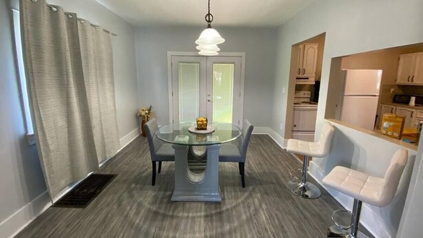 A compact kitchen with a dining area, featuring a round glass table, two bar stools, and a pendant light. - Niles Spacious 2-Story Family & Work Haven (Niles)