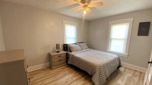 A bedroom with a bed, nightstand, and ceiling fan. - Niles Spacious 2-Story Family & Work Haven (Niles)