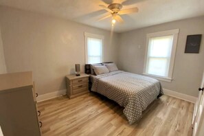 A bedroom with a bed, nightstand, and ceiling fan. - Niles Spacious 2-Story Family & Work Haven (Niles)