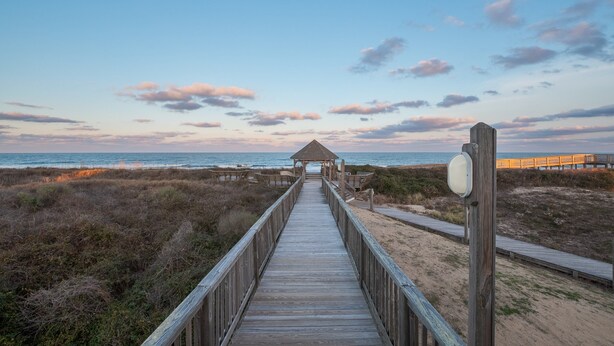 A wooden boardwalk leading to a beach gazebo with a wooden fence and a wooden walkway on the right. - 2910 - Dolphin's Den, Duck Condo | Pools, Tennis & Views (Duck)