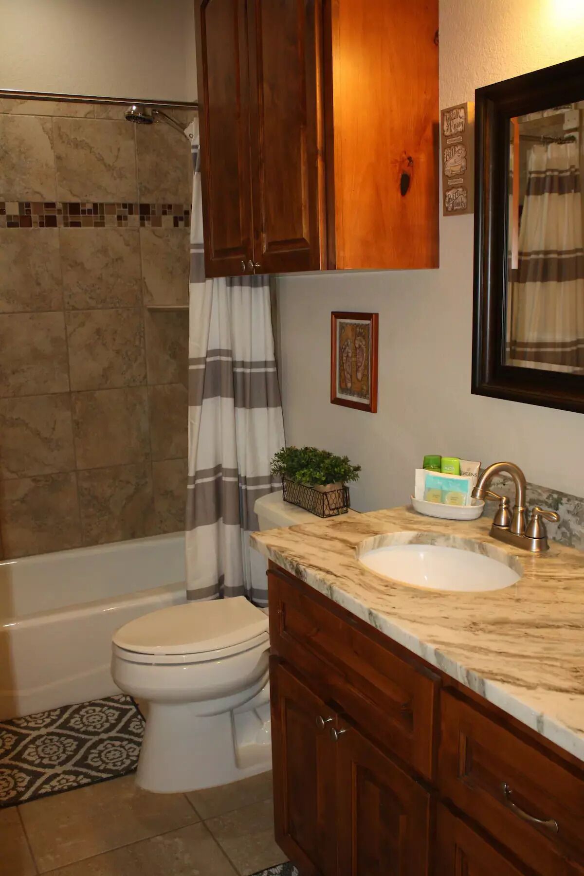 A bathroom with a bathtub, toilet, and vanity with a sink.