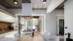 A modern kitchen with a wooden countertop, white cabinets, and a built-in oven.