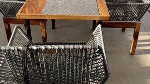 Un espace repas comprenant une table et des chaises, un élément décoratif central et une vue sur la ville grâce à de grandes fenêtres.