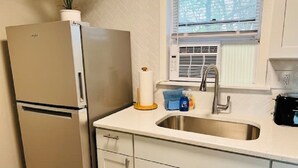 Een keuken met een roestvrijstalen koelkast, een spoelbak en kastjes.
