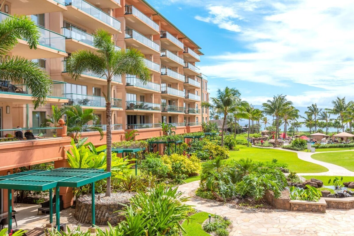 Un hôtel à plusieurs étages doté de balcons, d’un jardin bien entretenu avec différentes espèces de plantes et offrant une vue dégagée sur l’océan.