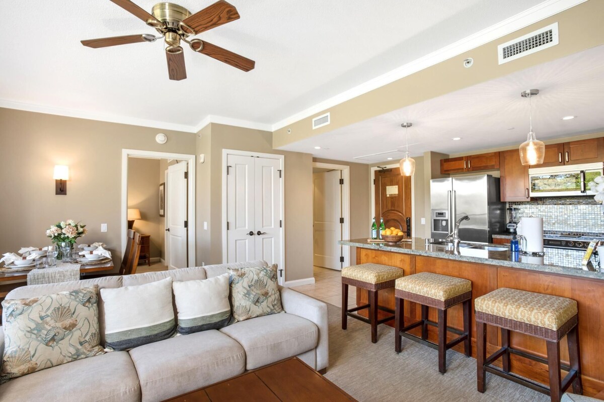 A modern kitchen with a central island, stainless steel appliances, and pendant lighting.