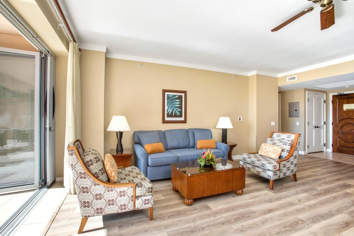 Un salon comprenant un canapé, deux fauteuils, une table basse et un ventilateur de plafond.