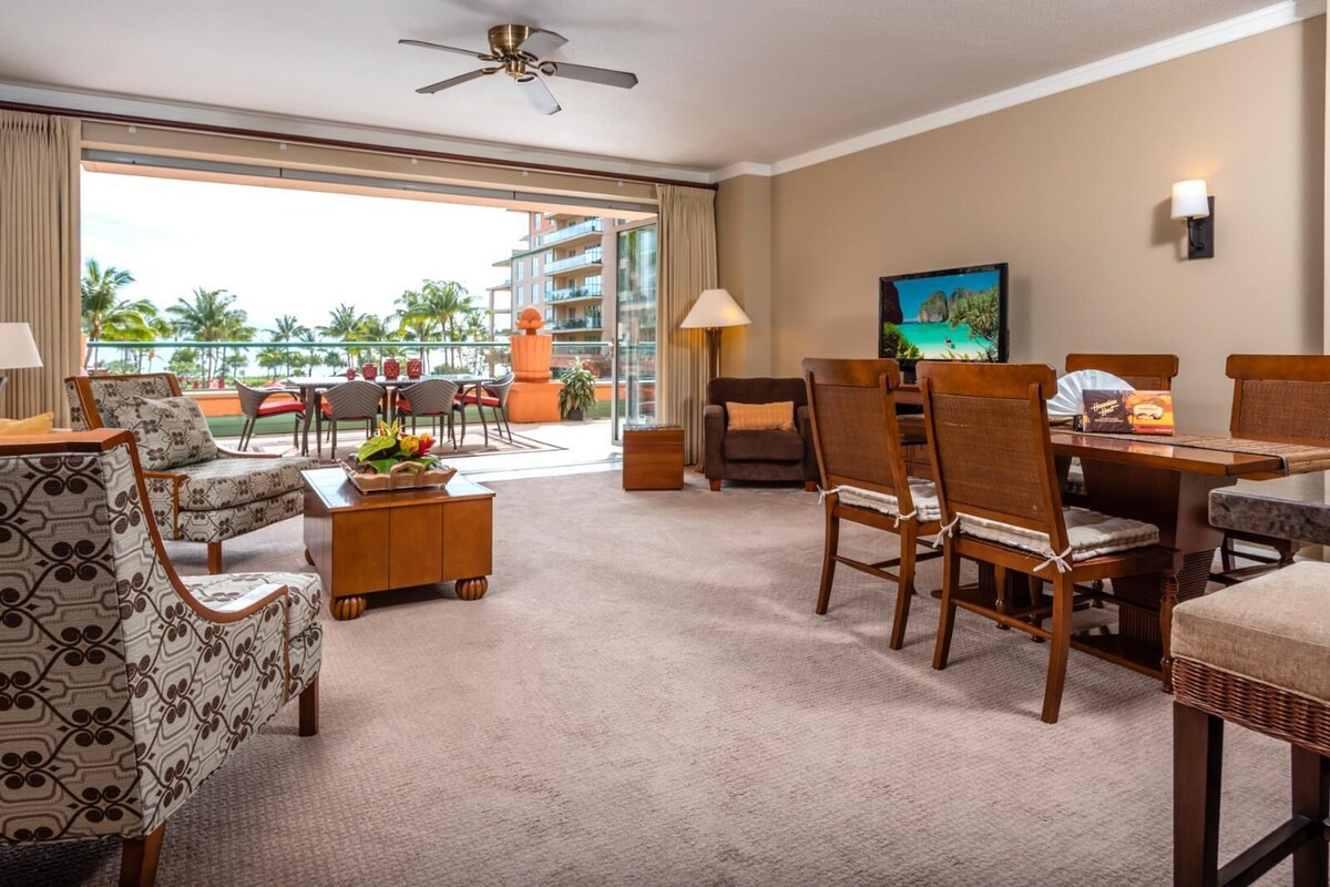 Une chambre d’hôtel avec balcon, un coin repas et un téléviseur.