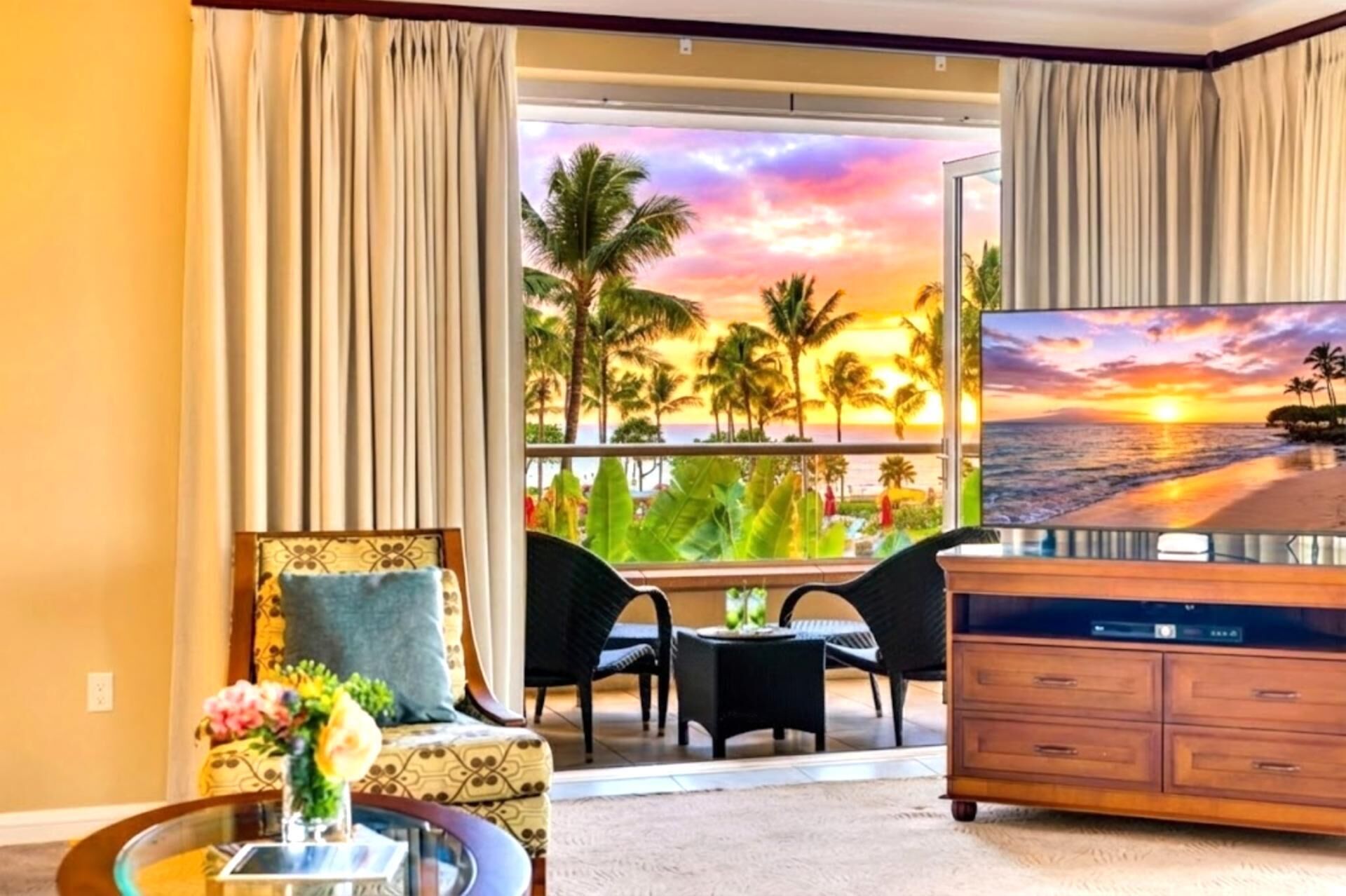 Une chambre d’hôtel avec balcon, une télévision, un canapé et une table à manger.