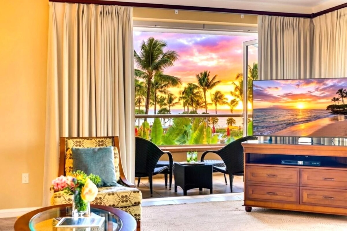 Une chambre d’hôtel avec balcon, une télévision, un canapé et une table à manger.