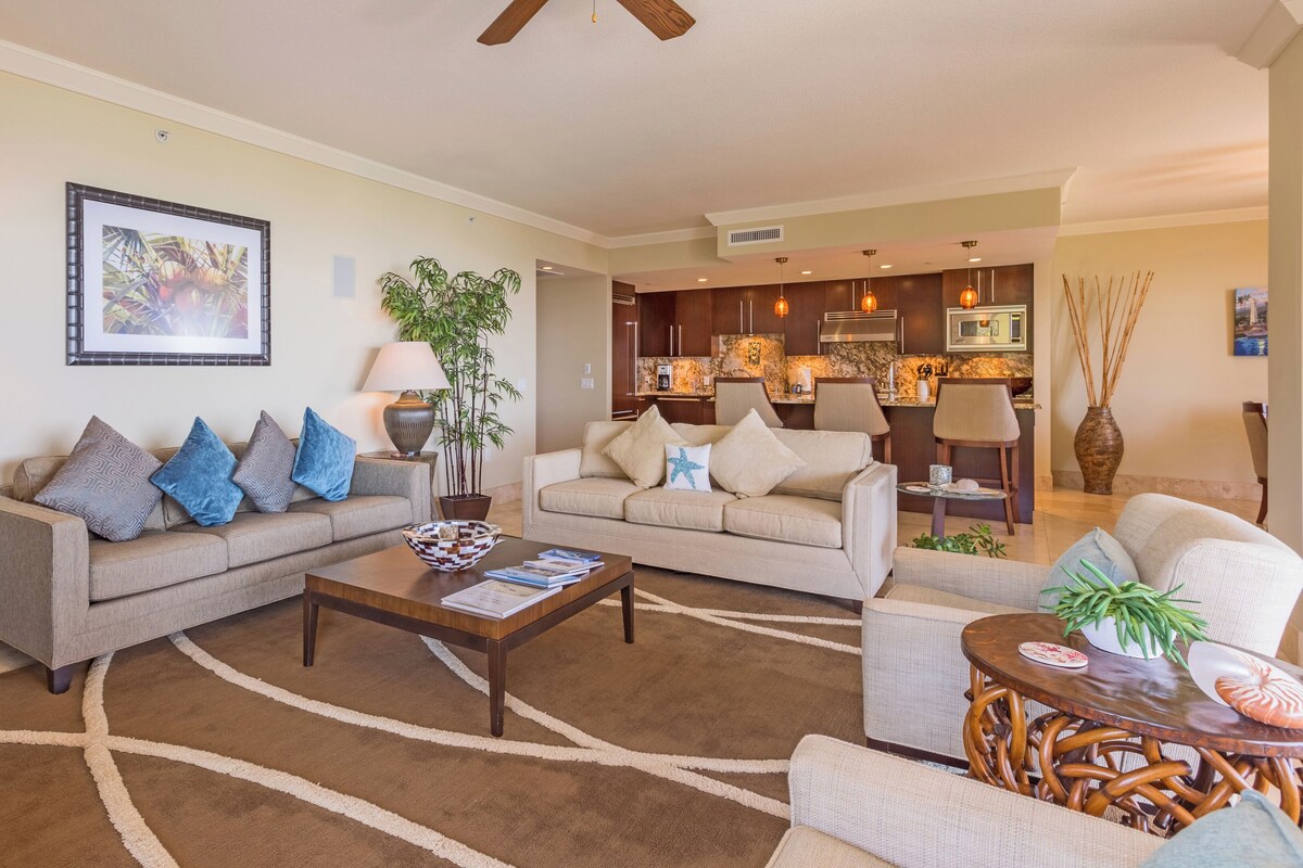 A modern living room with two sofas, a coffee table, and a dining area with a wooden table and chairs.