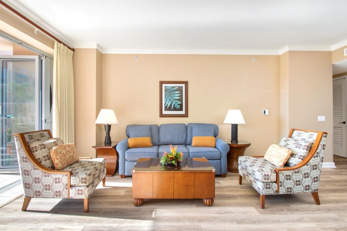 A living room with a sofa, two armchairs, a coffee table, and two lamps.