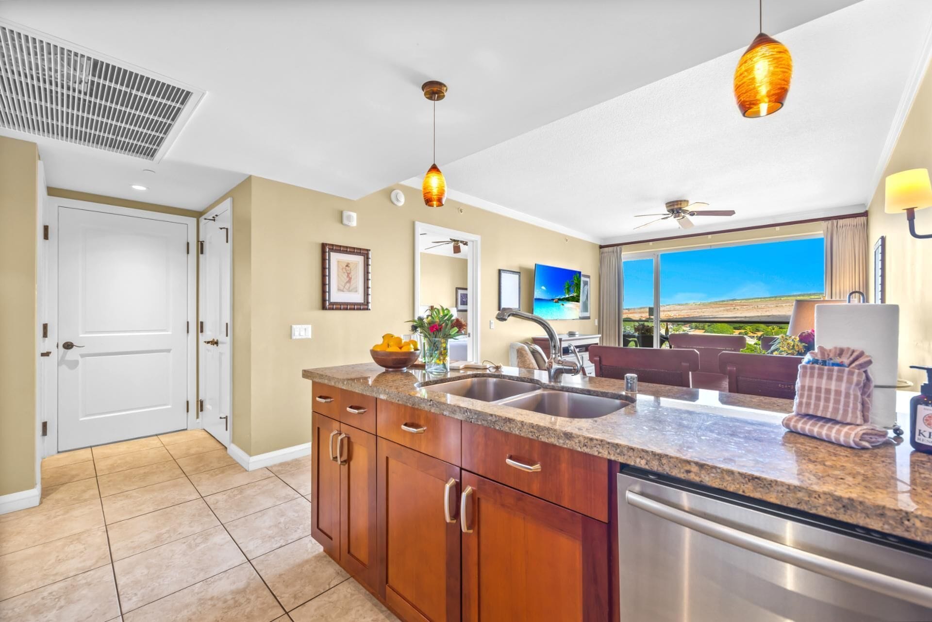 A modern kitchen with granite countertops, stainless steel appliances, and pendant lighting.