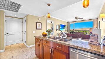 A modern kitchen with granite countertops, stainless steel appliances, and pendant lighting.