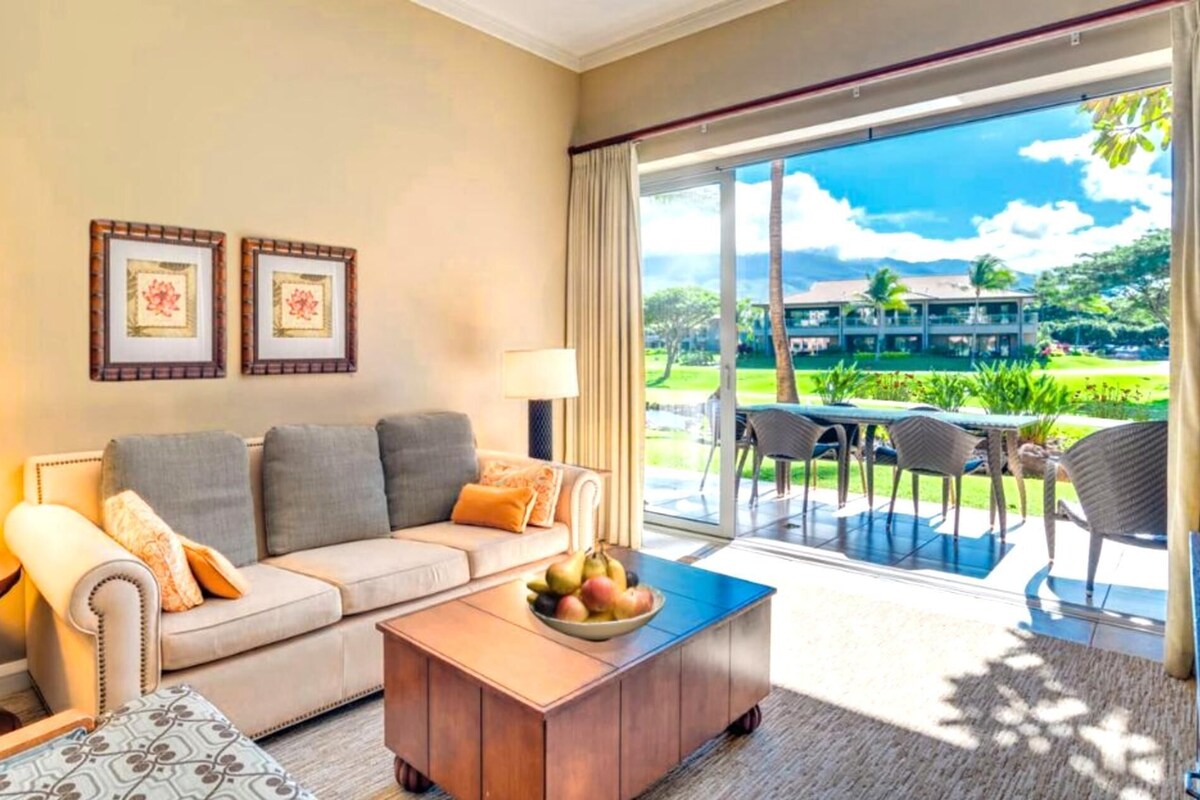 Un salon avec un canapé, une table basse et une vue sur une piscine et un espace extérieur.