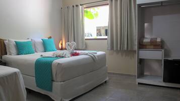 Habitación de hotel con cama, escritorio y ventana con cortinas.