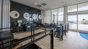 A modern hotel lobby with a pool area, large windows, and contemporary decor.
