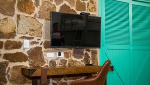 A stone wall with a flat-screen TV mounted above a wooden bar counter.