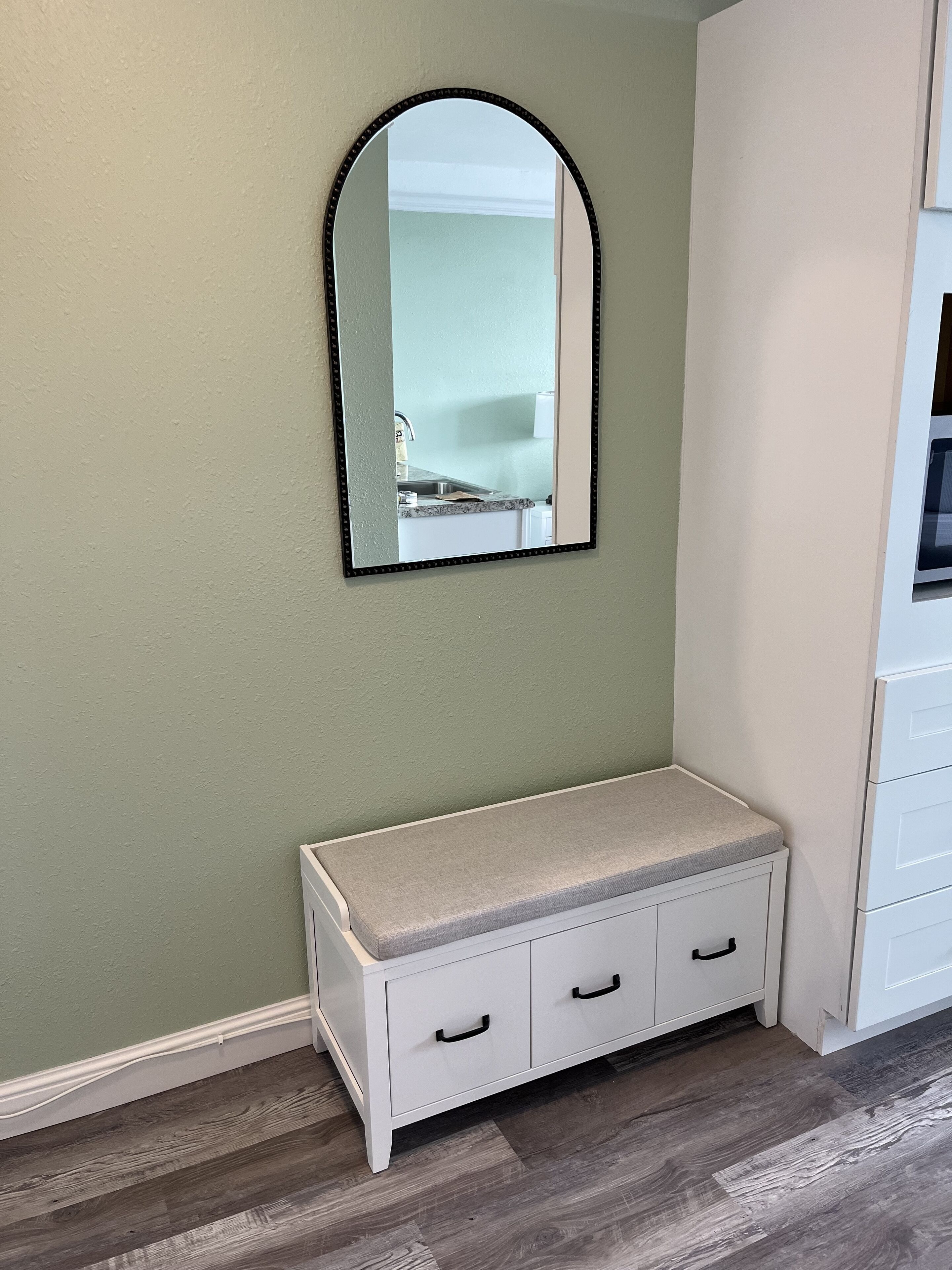 Une salle de bain avec un meuble-lavabo blanc, un miroir et un évier.
