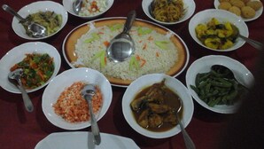 A table with various dishes, including rice, vegetables, and meat, suggesting a meal setting. - La Jungle Vista sigiriya (Sigiriya)
