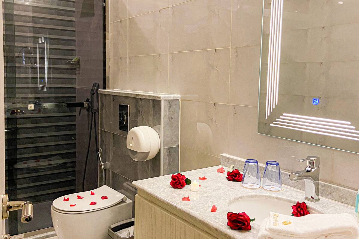 Un bagno moderno con WC, lavandino e doccia.