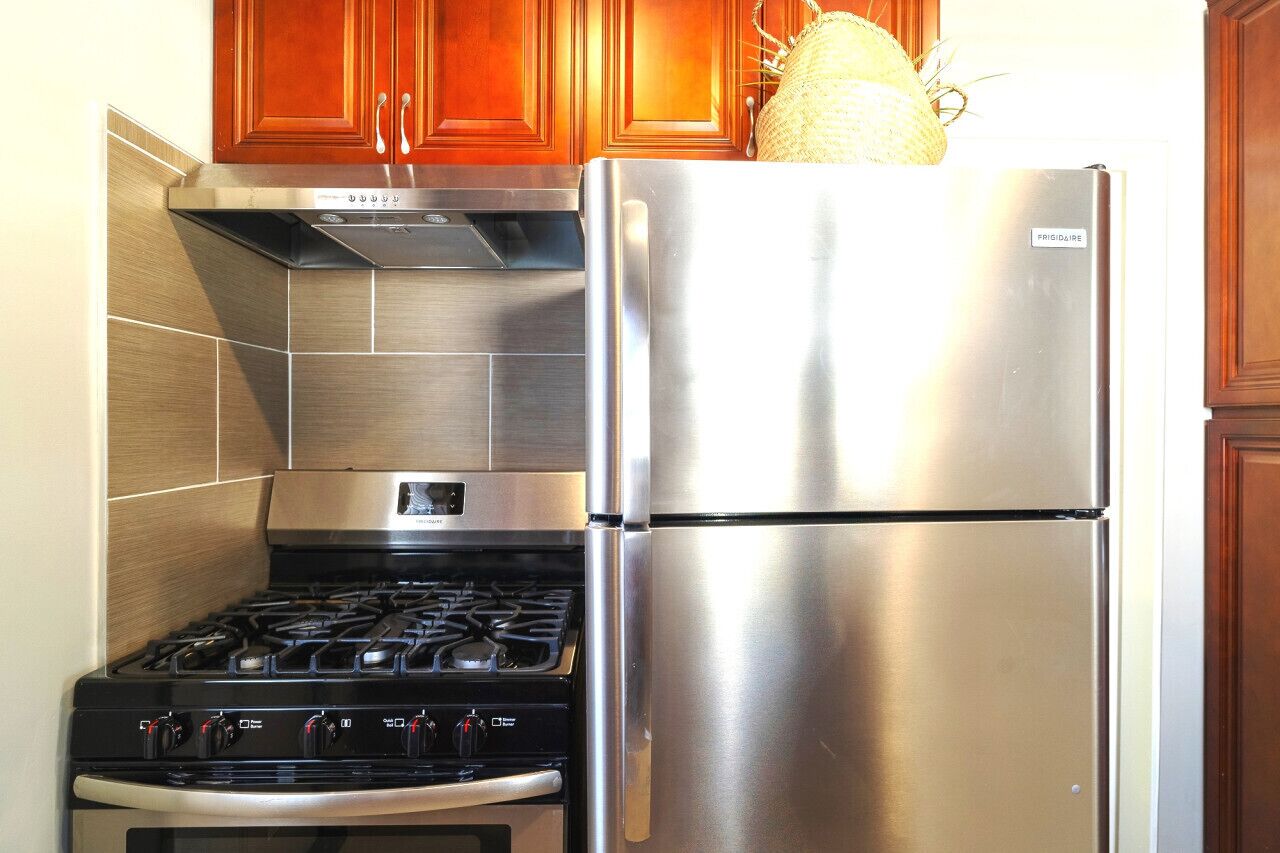 A kitchen with stainless steel appliances, including a refrigerator and a stove.