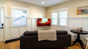 Ein Wohnzimmer mit Kamin, Fernseher und Essbereich mit Tisch und Stühlen.