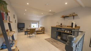 Un salon spacieux doté d’une cheminée, d’un téléviseur et d’un coin salon confortable.