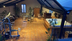 Tilava patio, jossa on kuntoiluvälineitä, ruokailualue ja poreallas.