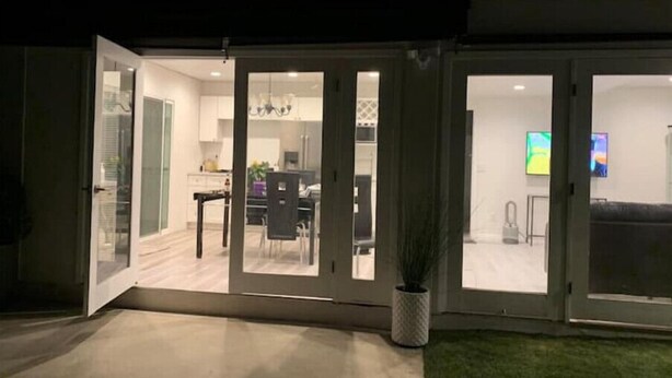 A modern house with a glass door leading to a dining area and a living room. - New Private house in historic area- Pasadena (Pasadena)