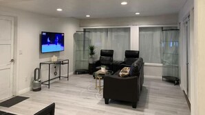 A modern living room with a flat-screen TV, two leather sofas, a coffee table, and a glass partition wall. - New Private house in historic area- Pasadena (Pasadena)