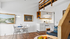 A modern living room with a dining area, a kitchen, and a loft bedroom. - 1 bedroom beach front apartment in Fanø (Fanø)