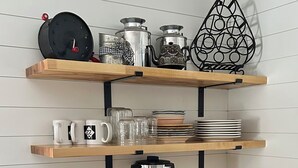Eine Küche mit Holzarbeitsplatten, einer Edelstahl-Kaffeemaschine und einem weißen Schrank.