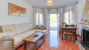 Una sala de estar con un sofá, una mesa de centro de madera y un comedor con una mesa y sillas.