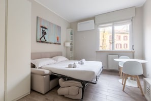 Un dormitorio moderno con cama, escritorio y ventana.
