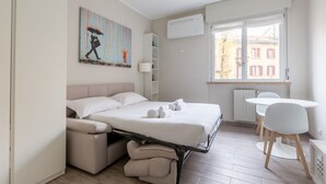 Une chambre moderne avec un lit, un bureau et une fenêtre.