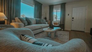 Uma sala de estar moderna com um sofá, uma mesa de centro e um ventilador de teto.
