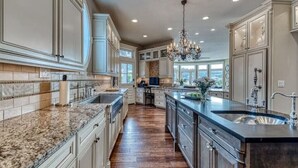 A spacious kitchen with granite countertops, stainless steel appliances, and a large island with a sink. - Waterfront high end home-dock, hot tub fun

 (Gig Harbor)