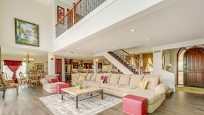 A spacious living area with a high ceiling, a staircase, and a dining area. - Group-Friendly Desert Escape! Putting Green, Pool (Phoenix)