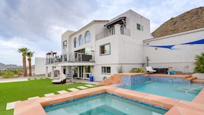 A modern house with a swimming pool, a balcony with outdoor furniture, and a well-maintained lawn. - Group-Friendly Desert Escape! Putting Green, Pool (Phoenix)