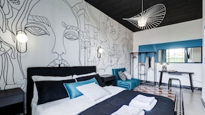 A modern hotel room with a large bed, a desk, and a wall mural. - BDC - Rome with a view! (Roma)