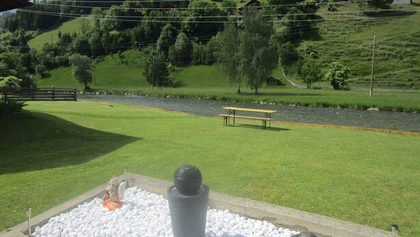 A riverside picnic area with a bench and a statue. - Haus Elena (Rangersdorf)