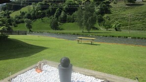 A riverside picnic area with a bench and a statue. - Haus Elena (Rangersdorf)