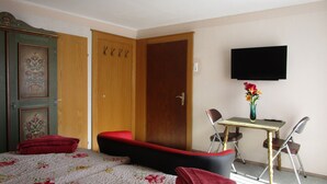 A bedroom with a bed, a desk with a chair, a television, and a wardrobe. - Haus Elena (Rangersdorf)